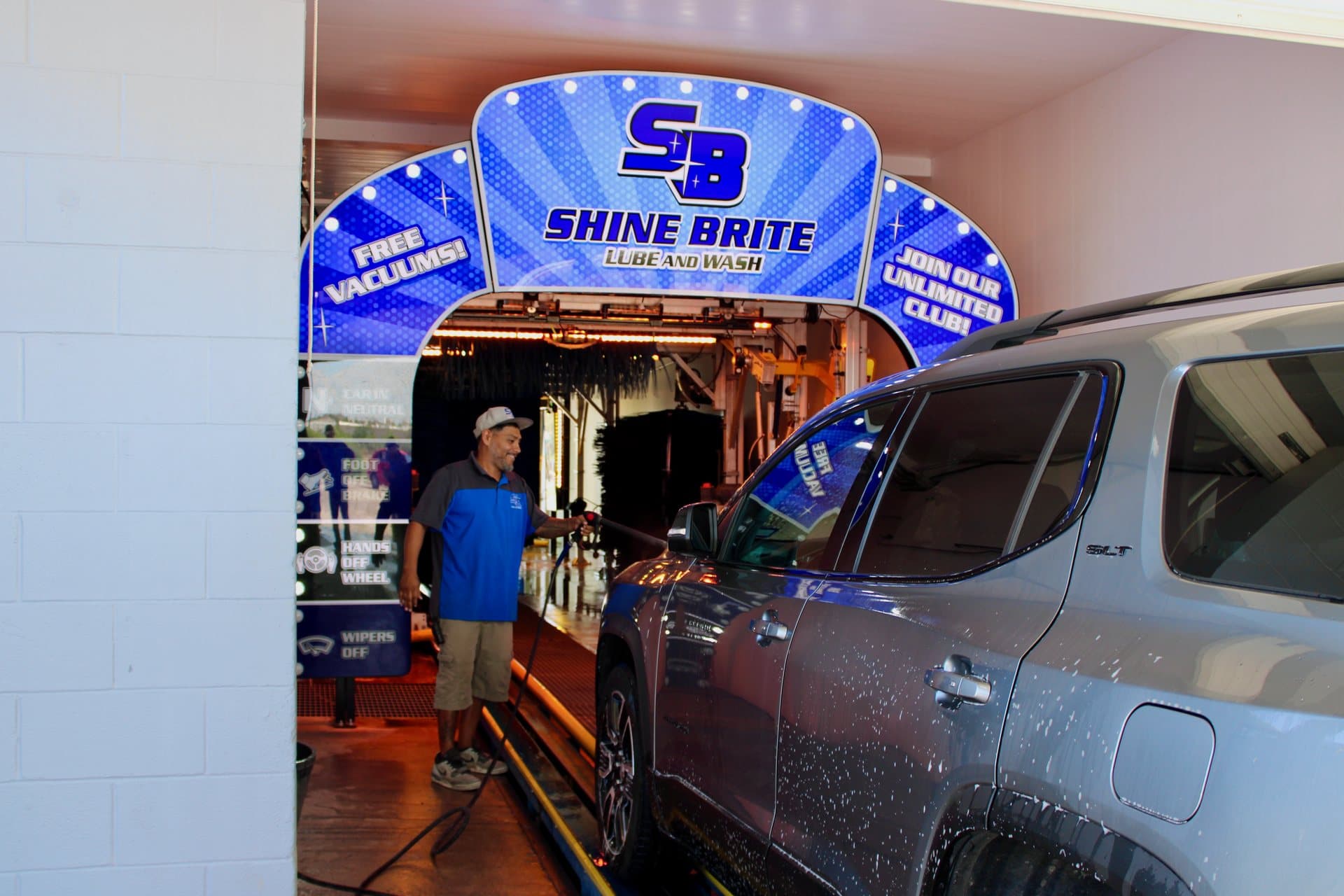 A crew member greeting a silver SUV at the tunnel entrance