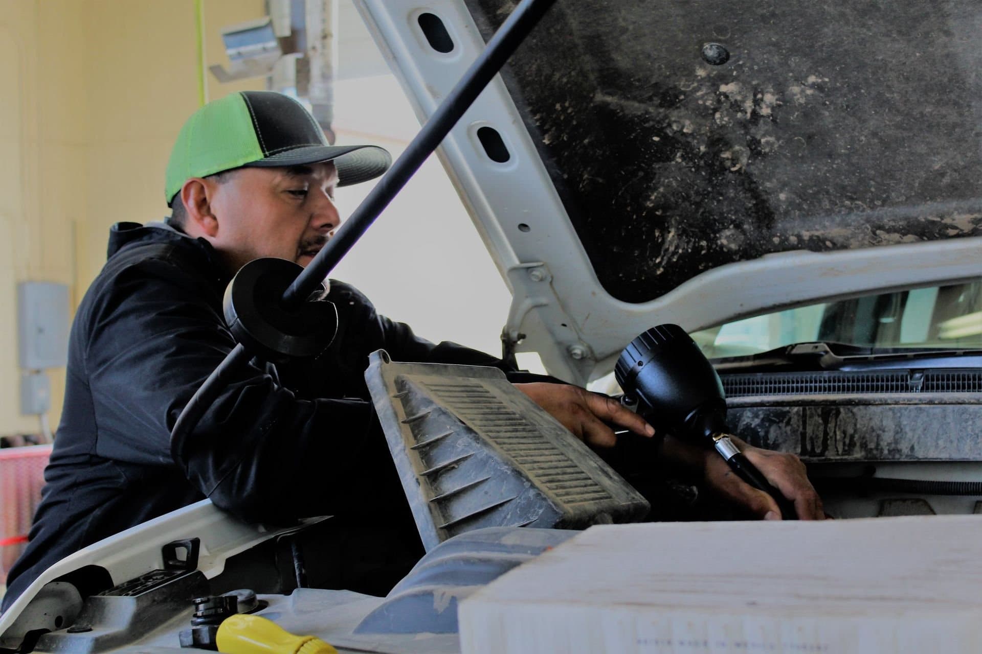 A technician working under the hood of a truck at the lube center